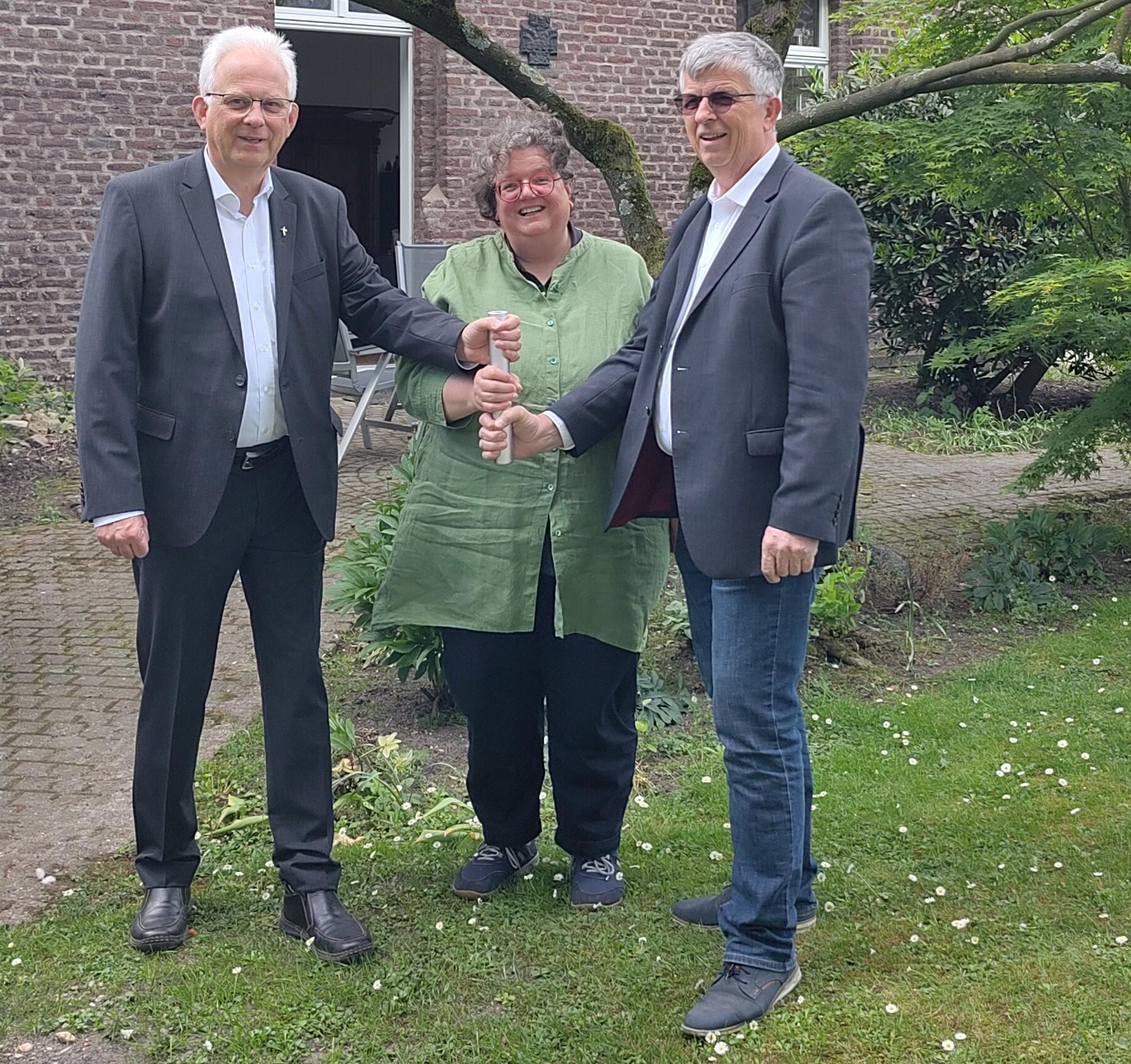 Als Team in der Region unterwegs: Propst Thomas Eicker (l.), Gabi Terhorst und Harald Hüller. Symbolisch teilen sie sich einen Staffelstab.
