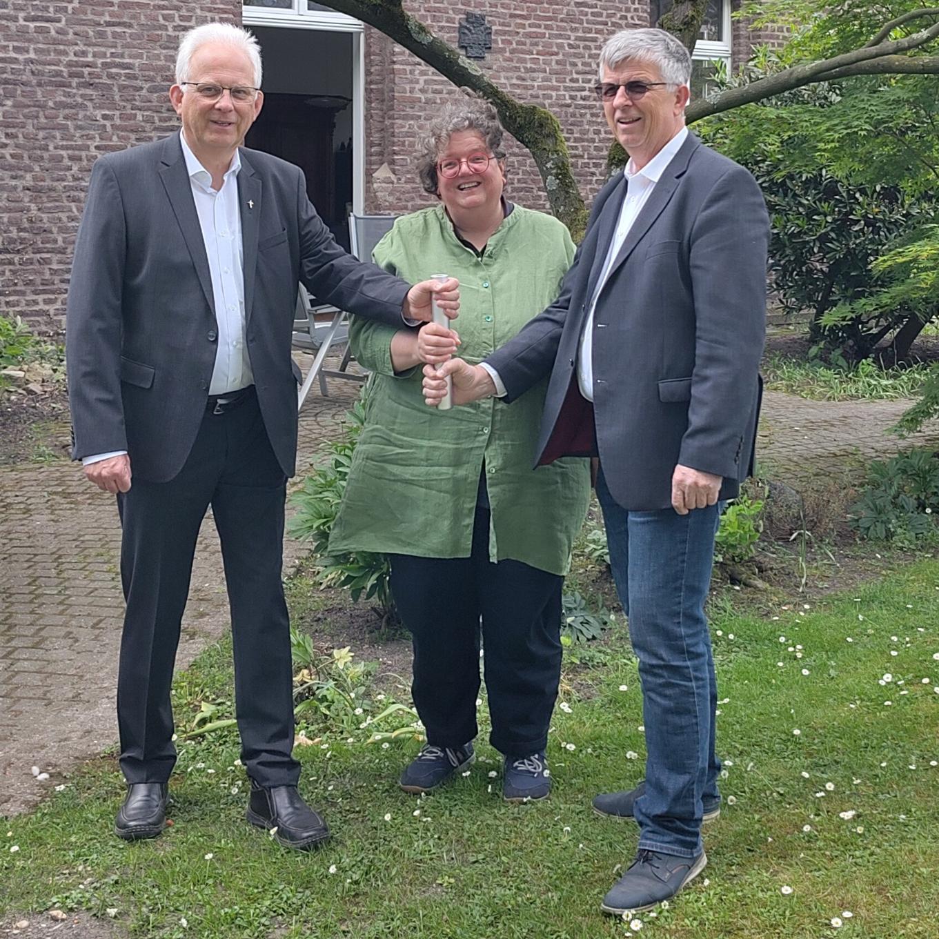 Als Team in der Region unterwegs: Propst Thomas Eicker (l.), Gabi Terhorst und Harald Hüller. Symbolisch teilen sie sich einen Staffelstab.